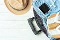 Open suitcase with travel accessories on white wooden table with copyspace. Royalty Free Stock Photo