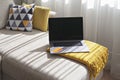 Open and switched off laptop on couch with credit card in cozy living room interior. Black Friday and Cyber Monday sale