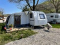 An open tent in front of a travel trailer at a caravan campsite. Riva, Istanbul, Turkey - April 04, 2022