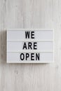 `We are open` text on a modern board, top view. Flat lay, overhead, from above