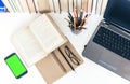 Open textbook, notebook, green screen smartphone, laptop computer, stack of books education back to school background, glasses and Royalty Free Stock Photo