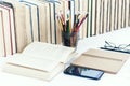 Open textbook, notebook, smartphone, stack of books education back to school background, glasses and pencils in plastic holder Royalty Free Stock Photo