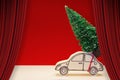 Open theater red curtains against a small pine tree on handmade cartoon toy car - Christmas holiday concept image