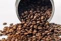 Open tin can and grains of black coffee on a white background. Fragrant roasted arabica beans on a white table. Traditional Royalty Free Stock Photo