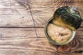 Open tin can with pink salmon fish on wooden background