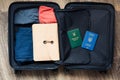 Open travel bag with color clothes, folder and ukrainian passport. Green book translation: \