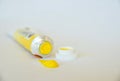 An open tube of artist`s cadmium yellow oil paint with dab of paint on white ground