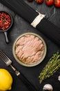 Open tuna tin, on black dark stone table background, top view flat lay