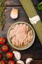 Open tuna tin, on old dark wooden table background, top view flat lay