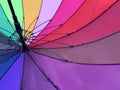 An open umbrella is bright, multi-colored, close-up. Background texture: umbrella mechanism. Large rain umbrella, all colors of Royalty Free Stock Photo