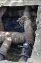 An open underground pipeline with valves in a brick well Royalty Free Stock Photo