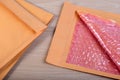 Open used yellow blank envelope with transparent bubble wrap or packaging shockproof on wooden table. Royalty Free Stock Photo