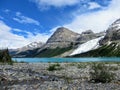 An open valley of rocks and creeks leading towards the teal waters of Berg Lake