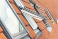 Open ventilation waterproof rooftop window exterior against sunny sky light. Velux style roof with red brick tiles Royalty Free Stock Photo
