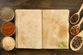 Open vintage book with spices on wooden background. Healthy vegetarian food. Royalty Free Stock Photo