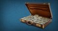 Open vintage briefcase full of 100 dollar bills on blue background. Copy space on the left. 3D illustration Royalty Free Stock Photo