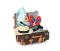 Open vintage suitcase with clothes and beach objects packed for summer vacation isolated Royalty Free Stock Photo