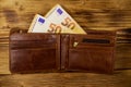 Open wallet with fifty euro banknotes on wooden background Royalty Free Stock Photo