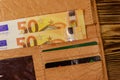 Open wallet with fifty euro banknotes on wooden background Royalty Free Stock Photo