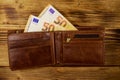 Open wallet with fifty euro banknotes on wooden background Royalty Free Stock Photo