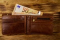 Open wallet with fifty euro banknotes on wooden background Royalty Free Stock Photo