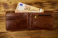 Open wallet with fifty euro banknotes on wooden background Royalty Free Stock Photo