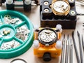 open watches in holders and tools on wooden table Royalty Free Stock Photo