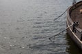 Open water copy space, edge of old wooden boat hull with ropes leading into the water Royalty Free Stock Photo