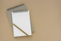 open white blank spiral notebook and yellow pencil isolated on brown background Royalty Free Stock Photo