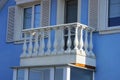 Open white concrete balcony with windows and a door on the blue wall Royalty Free Stock Photo