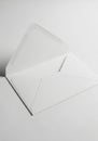 Open white envelope on a smooth, light-colored surface. The envelope flap is unfolded, revealing Royalty Free Stock Photo