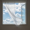 Open window with a sheer white curtain gently blowing inward. The window frames a Royalty Free Stock Photo