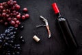 Open wine bottle. Grape and corkscrew on black background top view Royalty Free Stock Photo