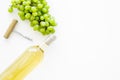 Open the wine concept. White wine in glass bottle near bunch of grapes and corkscrew on white background top view copy