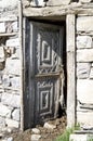 Open wood door with ornaments on cowshed in old stone house Royalty Free Stock Photo