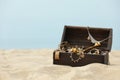 Open wooden chest with treasures on sandy beach, space for text Royalty Free Stock Photo