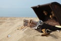 Open wooden chest with treasures on sandy beach, space for text Royalty Free Stock Photo