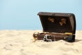 Open wooden chest with treasures on sandy beach, space for text Royalty Free Stock Photo