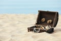 Open wooden chest with treasures on sandy beach, space for text Royalty Free Stock Photo