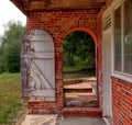 Open wooden door in brick wall to garden Royalty Free Stock Photo