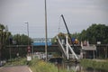 Open wooden drawbridge in the ring canal while on background maintenance crane driving