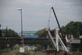 Open wooden drawbridge in the ring canal while on background maintenance crane driving