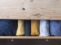 Open wooden dresser drawer with warm knitted woolen clothes. Home vertical storage. Wardrobe organizing