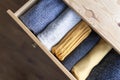 Open wooden dresser drawer with warm knitted woolen clothes. Home vertical storage. Wardrobe organizing