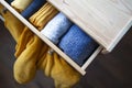 Open wooden dresser drawer with warm knitted woolen clothes. Home vertical storage. Wardrobe organizing