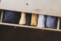 Open wooden dresser drawer with warm knitted woolen clothes. Home vertical storage. Wardrobe organizing