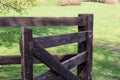 Open wooden gate of the cattle paddock on the background of the sunlit meadow Royalty Free Stock Photo