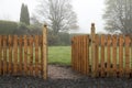 Open wooden gate and fence leading into a garden Royalty Free Stock Photo