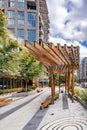 An open wooden gazebo near multi-story apartments on the street of an urban city