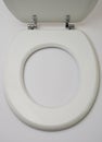 Open wooden toilet seat on white